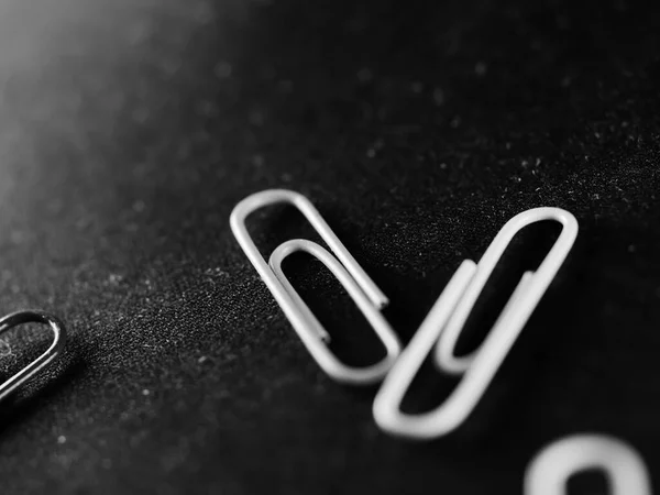 Selective Focus Grayscale Shot Two Scattered Paperclips Light Shining Corner — Stockfoto