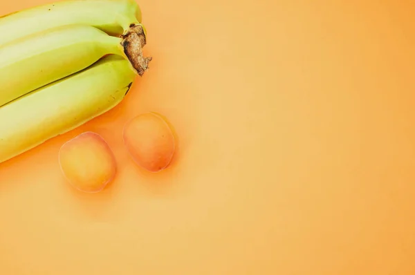 Colpo Alto Angolo Banane Mature Albicocche Isolate Uno Sfondo Arancione — Foto Stock