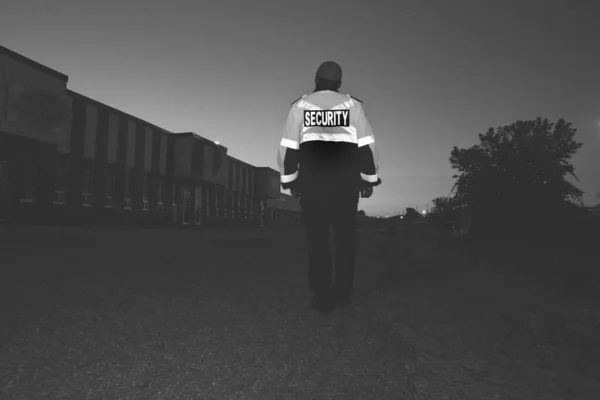 Grayscale Shot Security Guard Patrollingbusy Street City Sunset — Stock Photo, Image