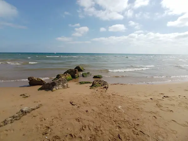 Piaszczysta Plaża Faliste Morze Pod Błękitnym Zachmurzonym Niebem — Zdjęcie stockowe