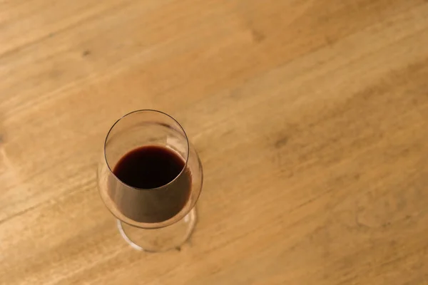 一个几乎空了的红酒放在木制桌子上的俯瞰图 — 图库照片