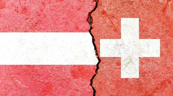 奥地利和瑞士的国旗在裂缝的墙面上 — 图库照片