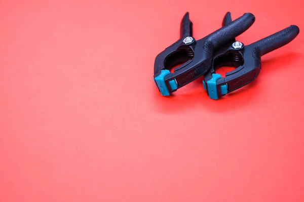 Closeup Two Plastic Spring Clamp Tools Isolated Red Background — Stock Photo, Image