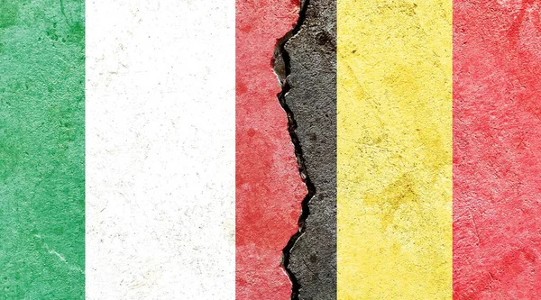 意大利和比利时的国旗挂在裂缝的墙面上 — 图库照片