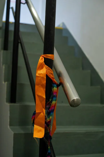 Вертикальный Снимок Оранжевых Радужных Лент Привязанных Полюсу Лестницы Украшения Мероприятия — стоковое фото