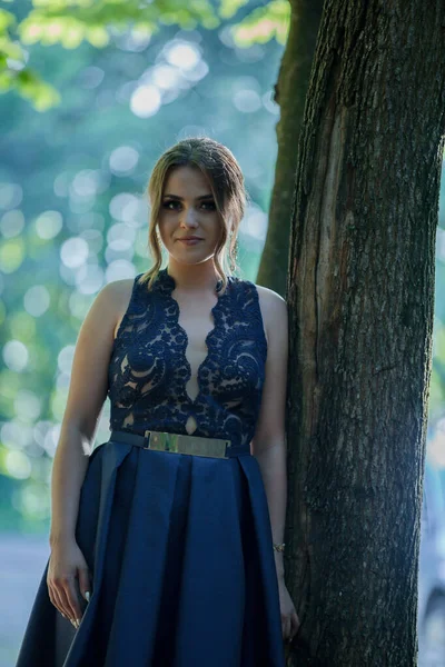 Una Atractiva Hembra Caucásica Con Elegante Vestido Azul Apoyado Árbol —  Fotos de Stock