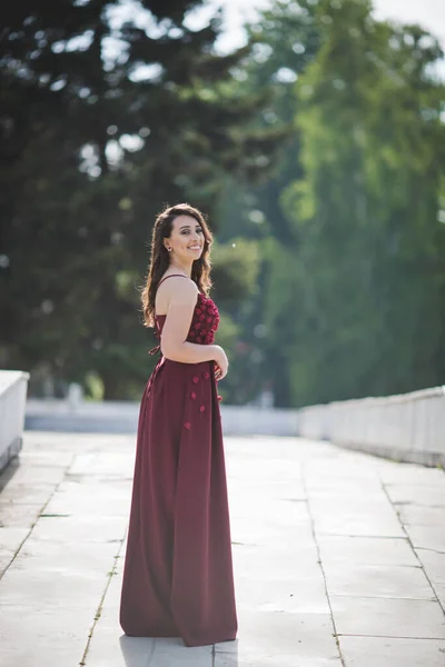 Gamzeli Bordo Elbiseli Parkta Poz Veren Mutlu Bir Beyaz Kadın — Stok fotoğraf