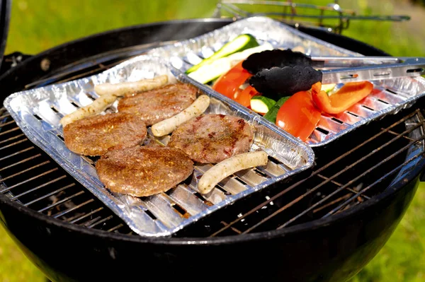 Selective Focus Shot Cutlets Sausages Vegetables Foil Plates Outdoor Grill — Fotografia de Stock