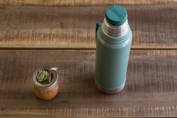 魔法瓶の横にあるヤシの木のカップにマットカフェインが豊富に含まれている飲み物のトップビュー — ストック写真