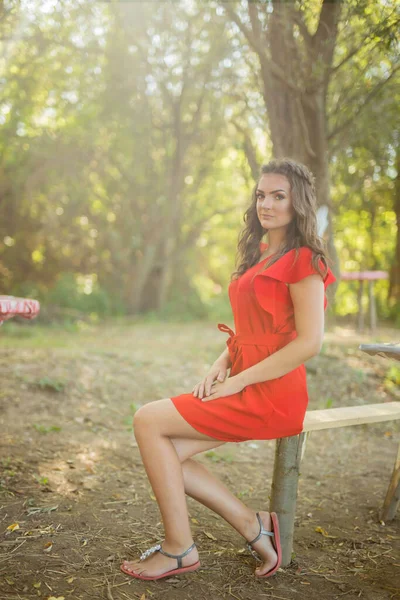 Uma Mulher Bonita Caucasiana Com Vestido Vermelho Sentado Banco Madeira — Fotografia de Stock