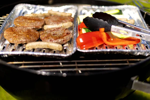 Selective Focus Shot Cutlets Sausages Vegetables Foil Plates Outdoor Grill — Zdjęcie stockowe