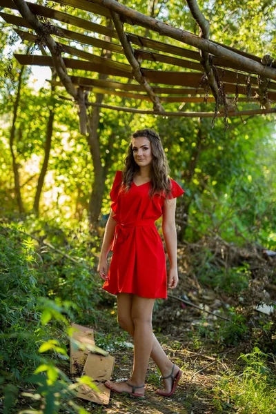Parkta Ağaçlarla Dolu Canlı Kırmızı Bir Elbise Giyen Çekici Bir — Stok fotoğraf
