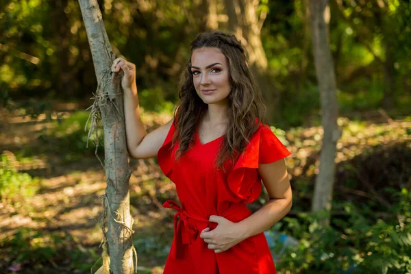 Atraktivní Běloška Zářivě Červených Šatech Pózující Parku Plném Stromů — Stock fotografie