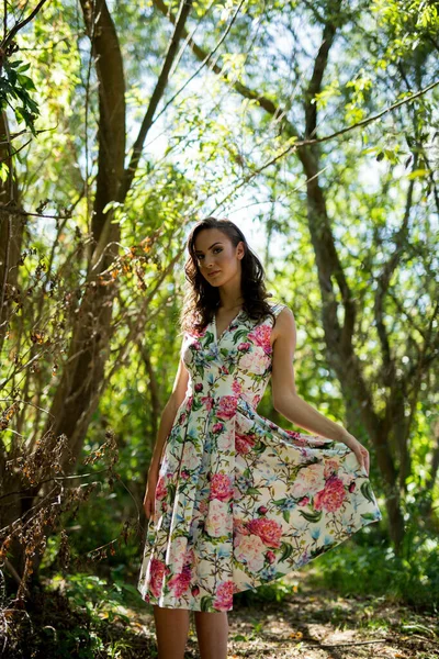Çiçekli Elbisesinin Eteğini Tutan Ormanda Poz Veren Beyaz Bir Kadın — Stok fotoğraf