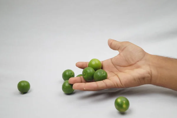 新鮮な緑の果物を手に持っている人の手のクローズアップショット — ストック写真