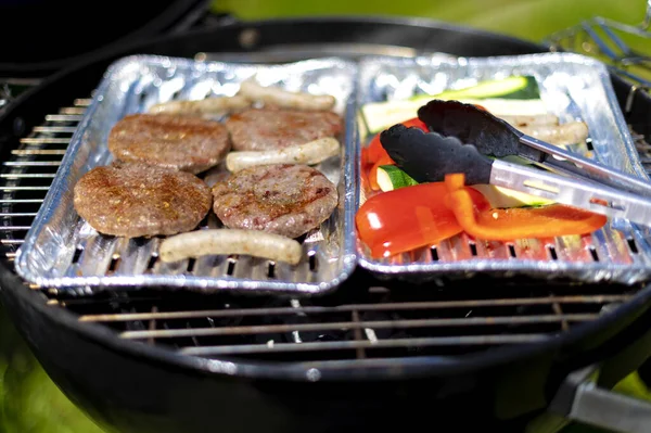 Selective Focus Shot Cutlets Sausages Vegetables Foil Plates Outdoor Grill — Fotografia de Stock