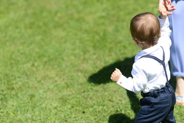 かわいい幼児のショット屋外で彼の母親の手を握って歩く — ストック写真