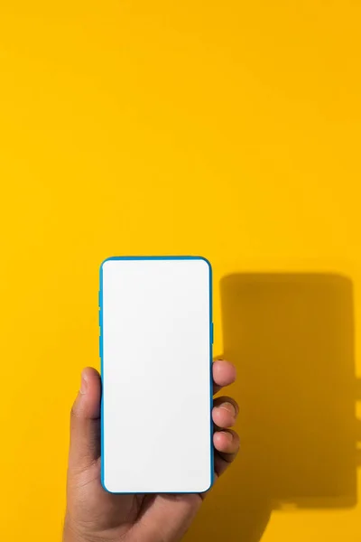 Vertical Shot Hand Holding Blue Smartphone Blank Screen Yellow Background — Foto de Stock