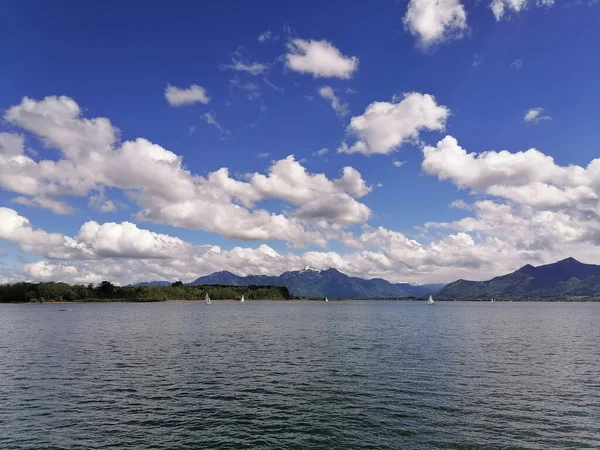 一个迷人的景象 是一个平静的湖 背景是多云的天空 群山环抱着它 — 图库照片