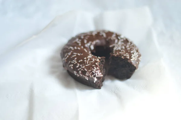 Primer Plano Delicioso Donut Chocolate Mordido Una Servilleta —  Fotos de Stock