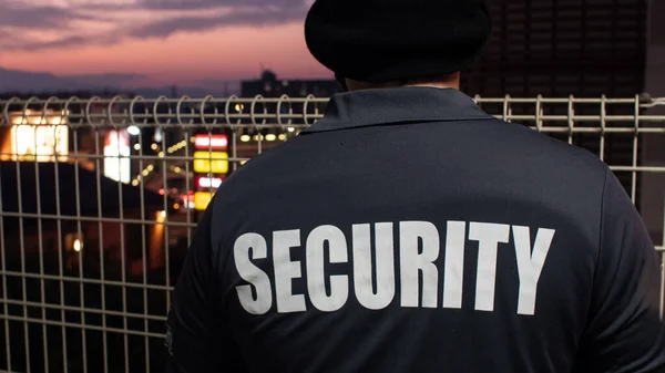 Een Achteraanzicht Van Een Bewaker Kijkend Door Straat Zonsondergang — Stockfoto