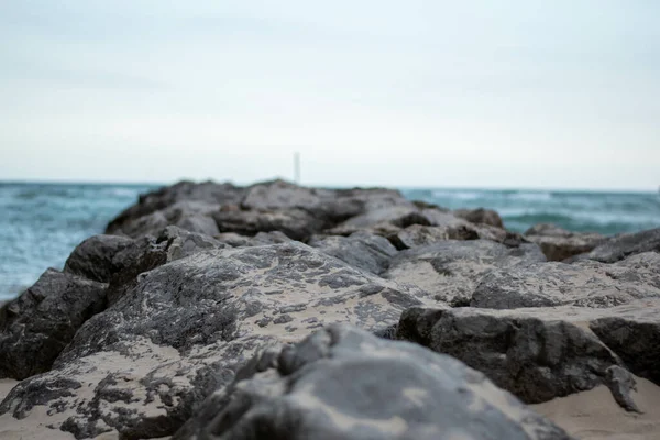 Zbliżenie Ujęcie Linii Kamieni Błękitnym Tle Oceanu — Zdjęcie stockowe