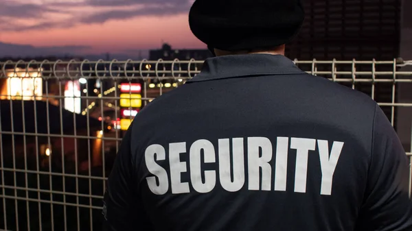 Een Achteraanzicht Van Een Bewaker Kijkend Door Straat Zonsondergang — Stockfoto