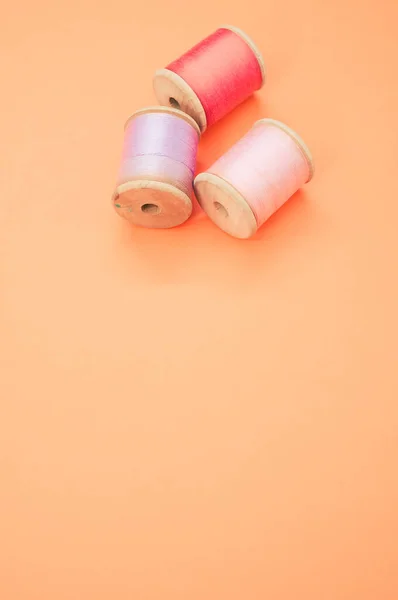 Een Kleurrijke Naaigaren Geïsoleerd Een Pastel Oranje Achtergrond Met Vrije — Stockfoto