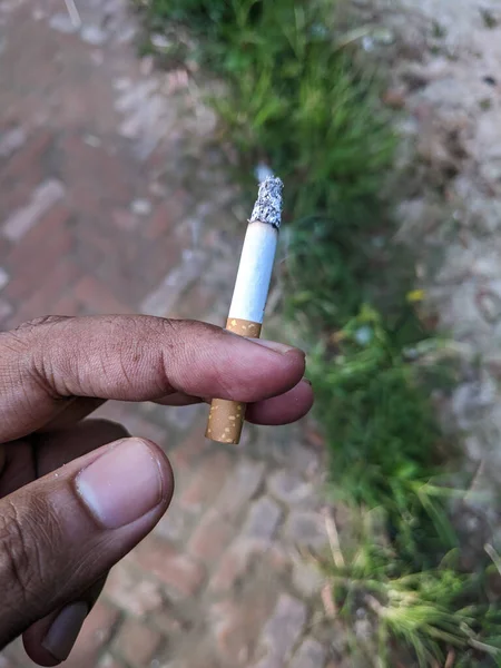 Foco Seletivo Cigarro Entre Dedos Mão Uma Pessoa Contra Fundo — Fotografia de Stock