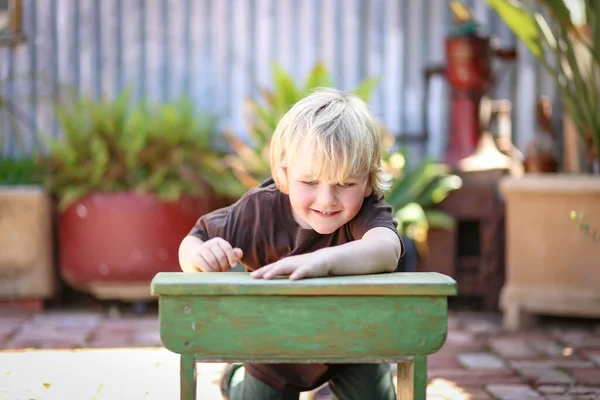 Happy Adorable Blonde Australian Kid Sitting Leaning Small School Table — Stockfoto