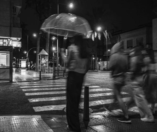 夜间在街上行走的行人的灰度照片 — 图库照片
