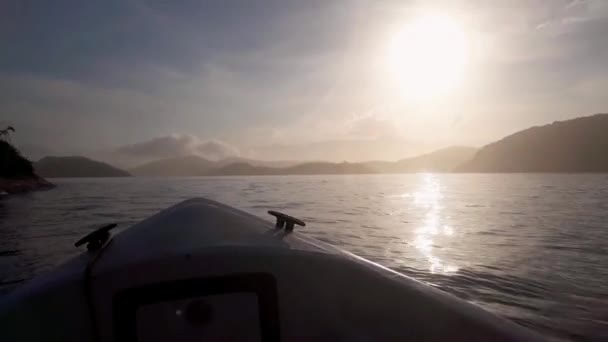 Hdの太陽の下で輝く山々に囲まれた海を航海するボート — ストック動画