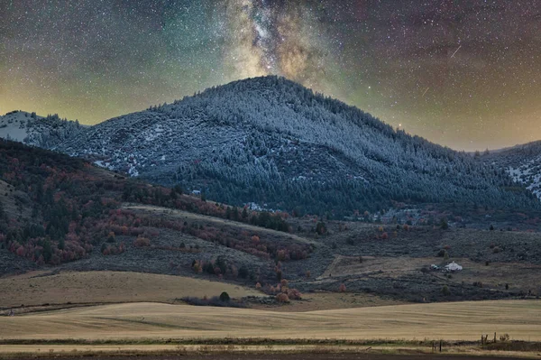 透过白雪覆盖的群山 你可以看到五彩斑斓的银河在天空中闪烁着光芒 这是令人惊叹的景象 — 图库照片
