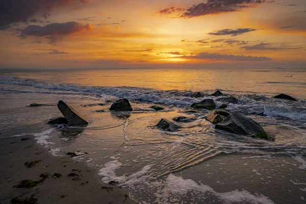 Turuncu Günbatımında Kıyıda Taşlarla Birlikte Nefes Kesici Bir Deniz Manzarası — Stok fotoğraf