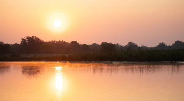 Sebuah Gambar Horisontal Dari Sebuah Danau Damai Mencerminkan Langit Oranye — Stok Foto