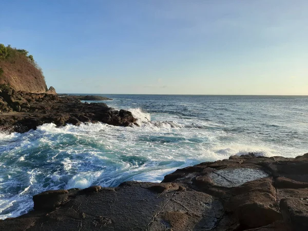 岩の台地と半島の間を高速で流れ インドネシアのジャワ島のWediomboと呼ばれるサーフビーチで岩に衝突する大きな波 — ストック写真