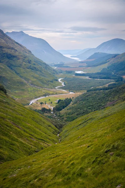 Vertical Shot Stream Mountains Covered Greenery Bright Sky — Stock Fotó