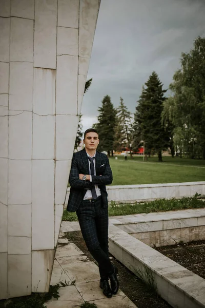 stock image A caucasian young businessman in a suit and tie standing in the park