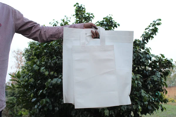 Hand Holding Two White Reusable Handbags Background Green Shrub — Fotografia de Stock