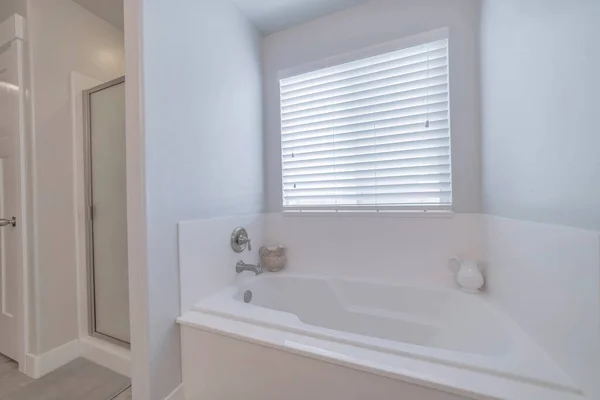 在白色浴室的盲窗下的浴缸 — 图库照片