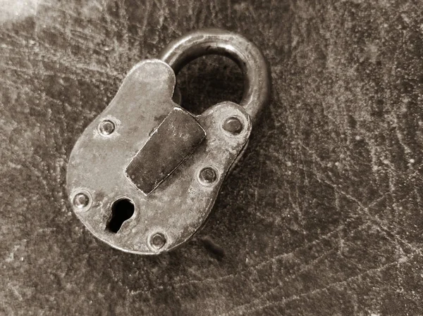 在带有复制空间的刮破的灰色金属表面上的一把旧挂锁的特写镜头 — 图库照片