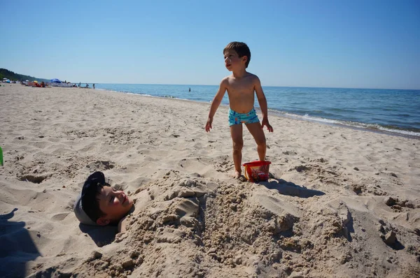 Pobierowo ポーランド 2021年6月7日 若い男の子が砂の中に掘り 暖かい日に砂浜でおもちゃのバケツを持っています — ストック写真