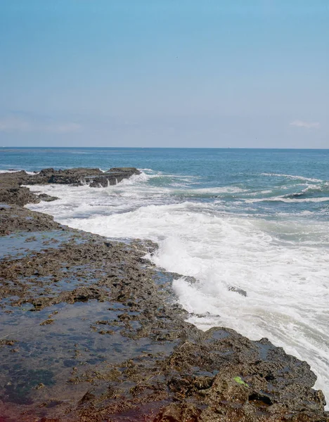 Вертикальний Знімок Морського Пейзажу Пінистим Узбережжям Під Блакитним Чистим Небом — стокове фото