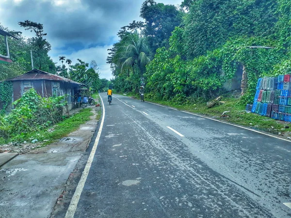 熱帯の木々や森に囲まれた道路上のバイカーのカップル — ストック写真