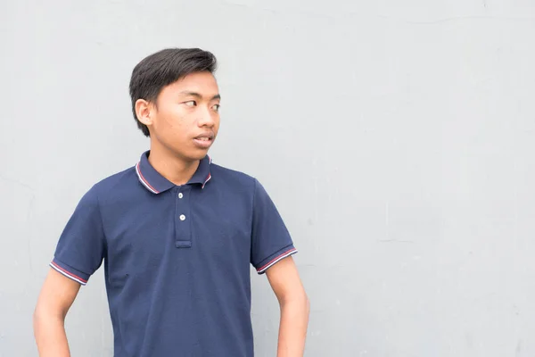 Indonéský Chlap Modrým Tričkem Dívající Kameru Podezřívavou Tváří Bílém Pozadí — Stock fotografie