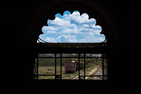 Поезд Рельсах Облачно Голубым Небом Видно Через Арочное Окно Железнодорожной — стоковое фото