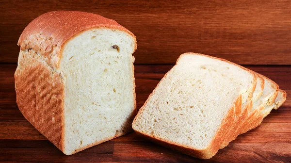 烤面包在厨房木制桌子上的一小块烤面包的特写镜头 旁边有薄片 — 图库照片