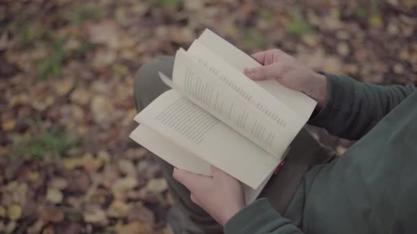 Ένας Άντρας Που Κοιτάζει Μέσα Από Ένα Βιβλίο Ένα Πάρκο — Αρχείο Βίντεο