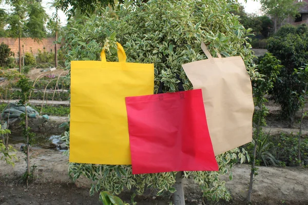 Primer Plano Tres Bolsos Colores Colgados Árbol Joven Jardín Artículos — Foto de Stock