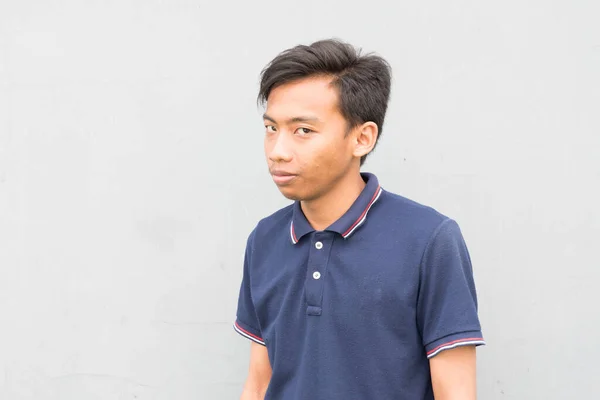 Indonesian Guy Blue Shirt Looking Camera Suspicious Face White Background — стоковое фото